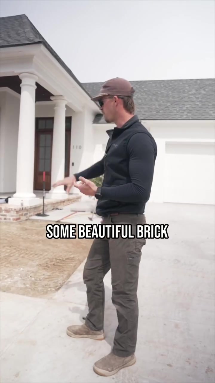 A presenter explains the brick steps and landscape work in progress outside a Sugar Mill Pond home.